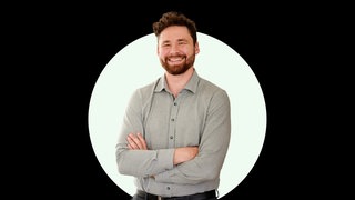 Paar- und Sexualtherapeut und Speaker Gavin Sexton steht mit verschränkten Armen vor einer schwarzen Wand mit weißem Kreis.