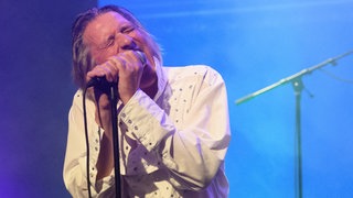 1980 hat die Band Fehlfarben mit "Monarchie und Alltag" ihr Debütalbum rausgebracht und damit ein prägendes Werk der deutschen Punkszene geschaffen. Zu Gast bei uns im Podcast sind Sänger Peter Hein und Gitarrist Thomas Schwebel. Hier zu sehen ist Sänger und Texter Peter Hein.