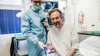 Gute Laune vor der Darmspiegelung! Prof. Straßburg (l.) wird mit diesem Endoskop an der Uniklinik Bonn gleich den Darm von Eckart von Hirschhausen durchleuchten. Die Dokumentation "Hirschhausen und der Darm" ist in der ARD Mediathek abrufbar.
