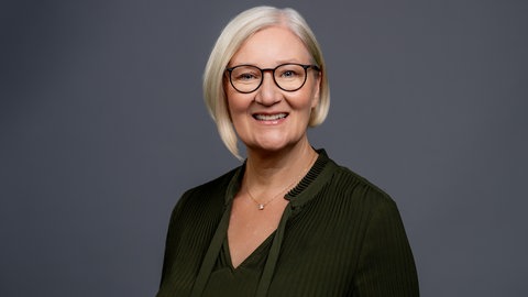 Porträt der lächelnden SWR4 Moderatorin und Redakteurin Iris Kruse in olivefarbenen Oberteil