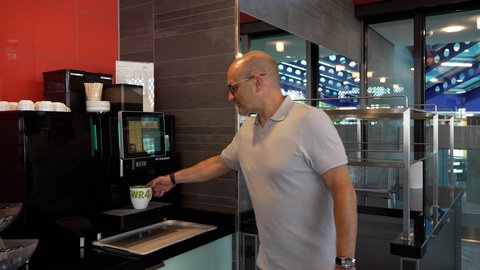 SWR4 Moderator Matthias Methner holt sich einen Kaffee in einer SWR4 Tasse