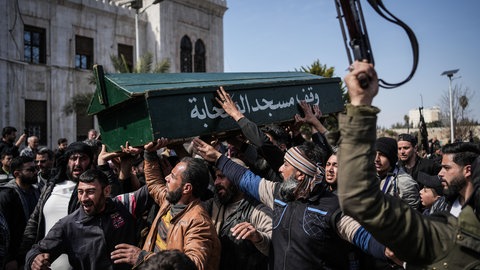 Syrische Kämpfer und Zivilisten tragen den Sarg eines Mitglieds der syrischen Sicherheitskräfte während seiner Beerdigung.