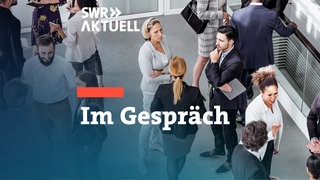 Zwei Frauen und ein Mann stehen im Kreis und sind in ein Gespräch vertieft.