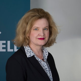 Katja Burck steht vor dem Logo von SWR Aktuell.