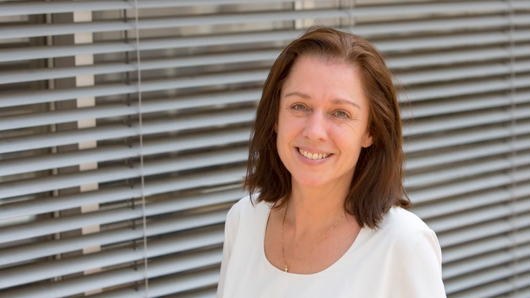 Petra Waldvogel steht im Gang eines SWR-Gebäudes.