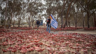 Eine Frau mit einer israelischen und einer deutschen Flagge steht auf dem Nova-Festivalgelände in Re'im vor dem zweiten Jahrestag des von der Hamas verübten Anschlags vom 7. Oktober