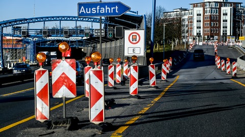 Fahrzeuge passieren die Warnschilder einer Autobahnbaustelle an der Auffahrt zur A7 in Hamburg Stellingen