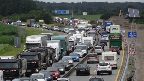 Fahrzeuge stauen sich in einer Baustelle auf der Autobahn A7, bei der eine Fahrbahn komplett erneuert wird.