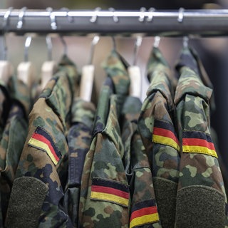 Feldjacken hängen am Stand der Bundeswehr bei der Computerspiele-Messe Gamescom.