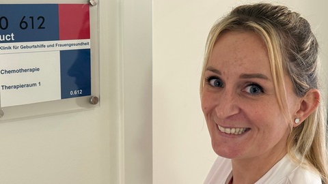 Beliebteste Pflegerin: Eine Mitarbeiterin in der Pflege schiebt eine Person in einem Rollstuhl über eine Krankenhaus-Flur.