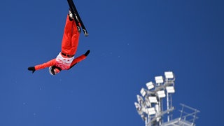 Emma Weiß fliegt bei einem Wettbewerb der Olympischen Winterspiele in Peking 2022 kopfüber durch die Luft.