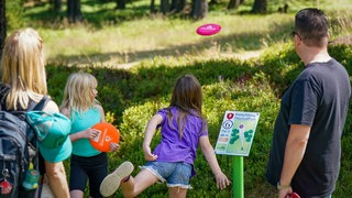Eine Familie spielt Discgolf im Kreischberg DiscGolfPark.