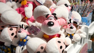 Im "duo Flagshipstore" am Potsdamer Platz stehen am Tag des Diddl-Launch Diddl-Mäuse auf einem Regal zum Verkauf bereit. Die Maus im Vordergrund trägt eine rosa Latzhose. Im Hintergrund sind noch weitere Diddl-Produkte zu erkennen.
