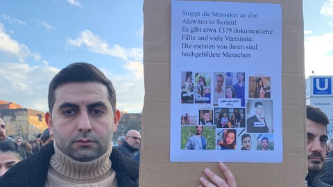 Ali Muhammad demonstriert auf dem Stuttgarter Schlossplatz für internationale Hilfe für Alawiten in Syrien. 