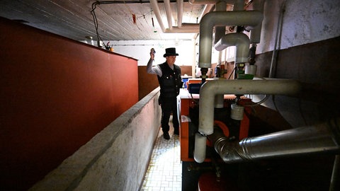 Ein Kaminkehrer begutachtet eine Ölheizung im Keller eines Einfamilienhauses. Die Bundesregierung hat sich auf Eckpunkte für das neue Gebäudemodernisierungsgesetzes verständigt. Es soll das Gebäudeenergiegesetz der Vorgängerregierung ablösen.