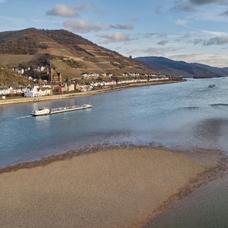 Ein Frachtschiff passiert auf dem Rhein die Stadt Lorch. 