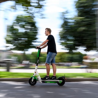 Ein Mann fährt in Stuttgart auf einem E-Scooter.