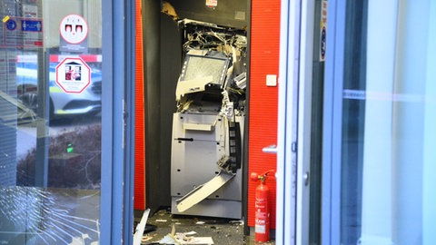 Ein gesprengter Geldautomat ist in einem Bankgebäude zu sehen.