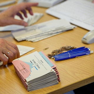 Eine Mitarbeiterin in einem Wahllokal bereitet die Wahlunterlagen für die Wähler vor