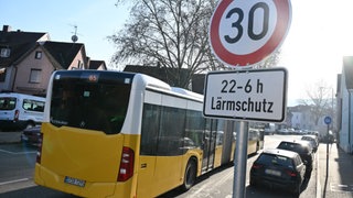 Ein Bus fährt auf einer Straße mit einer Tempo 30 Geschwindigkeitsbegrenzung.