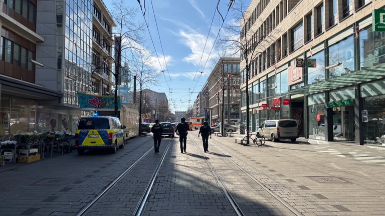 Drei Polizisten laufen durch die Mannheimer Innensstadt.