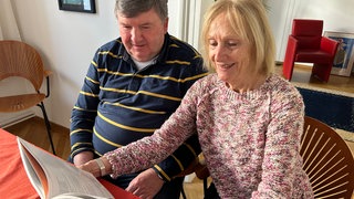 Wilhelm Kazmaier und Ute Wessels blättern in einem Buch