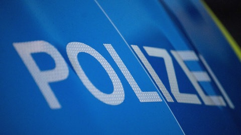 Das Wort Polizei ist auf der Karosserie eines Polizeifahrzeugs zu sehen.