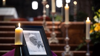 Ein Kondolenzbuch liegt im Dom während eines Gottesdienstes für den verstorbenen Papst neben einem Porträt des Pontifex. Das Oberhaupt der Katholischen Kirche war am Morgen im Vatikan verstorben.