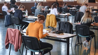 Symbolbild: Schüler sitzen in einer Aula in der Vorbereitungszeit für ihre Abschlussprüfung. Am Dienstag beginnen in Baden-Württemberg die Abschlussprüfungen in Hauptschulen, Werkrealschulen und Realschulen.