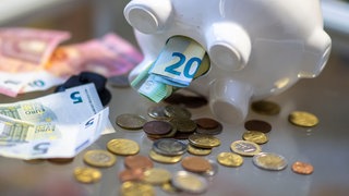 Geld steckt im Bauch eines Sparschweins. In Baden-Württemberg beklagen viele Kommunen einen dramatische Finanzlage.
