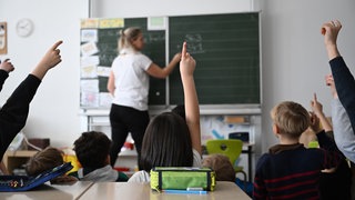 Schüler einer Grundschule arbeiten in einem Klassenzimmer an Mathematikaufgaben (Symbolbild).