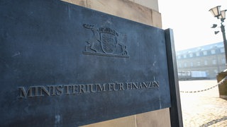 Ein Schild mit der Aufschrift "Finanzministerium Baden-Württemberg" steht vor dem Neuen Schloss in Stuttgart, dem Sitz des Ministeriums.
