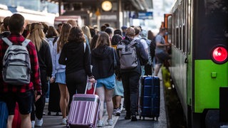 Zahlreiche Menschen steigen am Stuttgarter Hauptbahnhof in einen Flixtrain-Zug mit Ziel Berlin Hbf. 