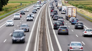 Autos fahren im zäh fließenden Verkehr über eine Autobahn.