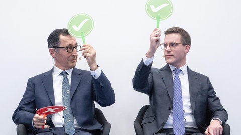 Die Spitzenkandidaten zur Landtagswahl in Baden-Württemberg, Cem Özdemir (Grüne,) und Manuel Hagel (CDU),sitzen bei einer Veranstaltung der BWIHK auf der Bühne. 