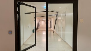 Eine schwarze Glastür zu einem langen Tunnel unter dem Landtag