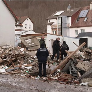 Einsatzkräfte durchsuchen die Trümmer eines Hauses