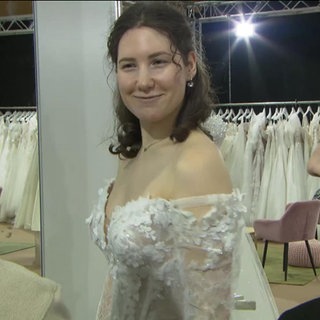 Eine junge Frau im Brautkleid auf einer Hochzeitsmesse