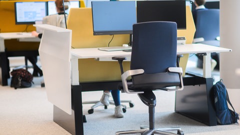 Arbeitsplätze mit Bildschirmen in einem Großraumbüro