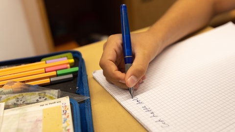 Ein Schüler der 6. Klasse schreibt in ein Heft. 