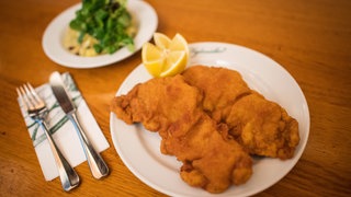 Zwei Wiener Schnitzel liegen auf einem Teller im Restaurant.