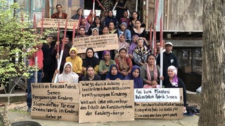 Plakate gegen Heidelberg Materials: In Indonesien stößt das Minenprojekt auf Kritik, weil es Bewohner und Umwelt gefährden könnte.