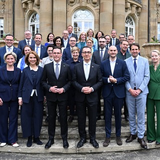 Ministerpräsident von Baden-Württemberg Cem (Grünen) und Manuel Hagel (CDU) stehen nach der Vereidigung der neuen Landesregierung mit den Ministern und den Staatssekretären vor der Villa Reitzenstein, dem Amtssitz des Ministerpräsidenten.