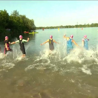 Sportlerinnen auf dem Weg in einen See