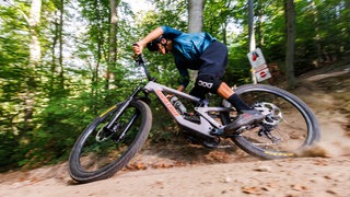 Ein Mountainbiker fährt einen Singletrail hinunter. 