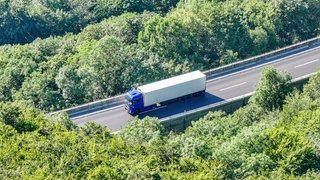 Ein Lastwagen mit einer blauen Zugmaschine und einem weißen Aufleger steht auf der A8 bei Wiesensteig. Wegen der Gefahr einer Explosion und eines Brandes werden im Ort rund 100 Menschen aus ihren Häusern evakuiert.