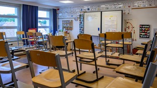 In einem Klassenraum einer Grundschule sind alle Stühle hochgestellt. 