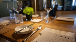 In einem Sternerestaurant ist ein Tisch für das Menü eingedeckt.