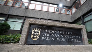 Ein Schild mit der Aufschrift Landesamt für Verfassungsschutz Baden-Württemberg steht vor dem Eingang der Behörde.
