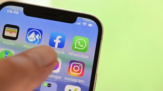 Auf einem Handy sind die Symbole von Apps von Sozialen Medien zu sehen.
